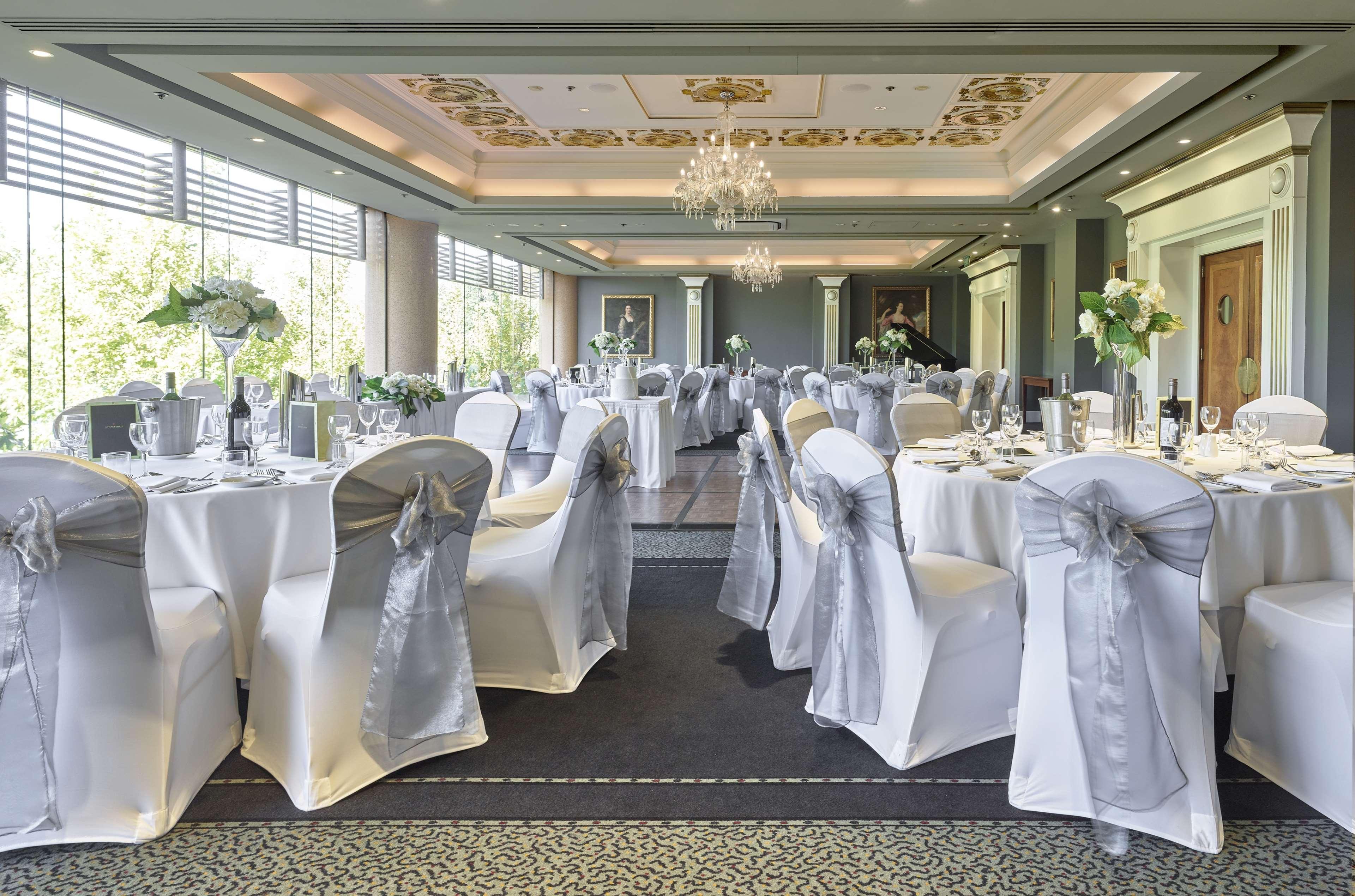 Hotel Stamford Plaza Adelaida Exterior foto The photo displays an elegantly arranged banquet hall. The room features several round tables covered with white tablecloths, each adorned with silver sashes on the chairs. There are floral centerpieces, possibly white flowers, on the tables, adding 